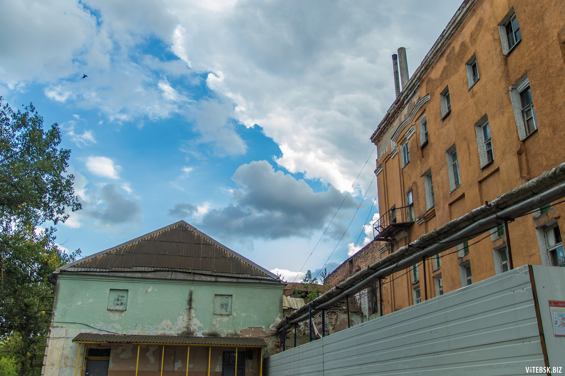 Старое здание XIX века стоит, упираясь в небо, на берегу Западной Двины.